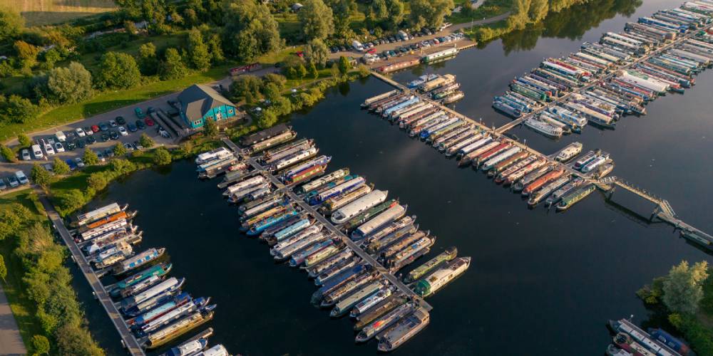Aerial view of Roydon Marina with narrowboats moored on the water